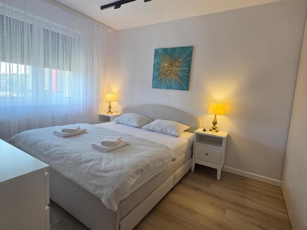 Un dormitorio blanco con una cama y dos mesitas de noche. en Vestiq ARAD, en Arad