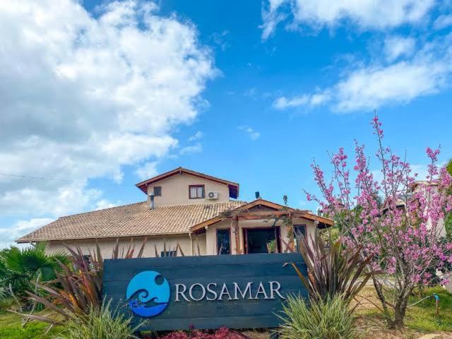 a house with a sign in front of it at Pousada Rosamar in Praia do Rosa