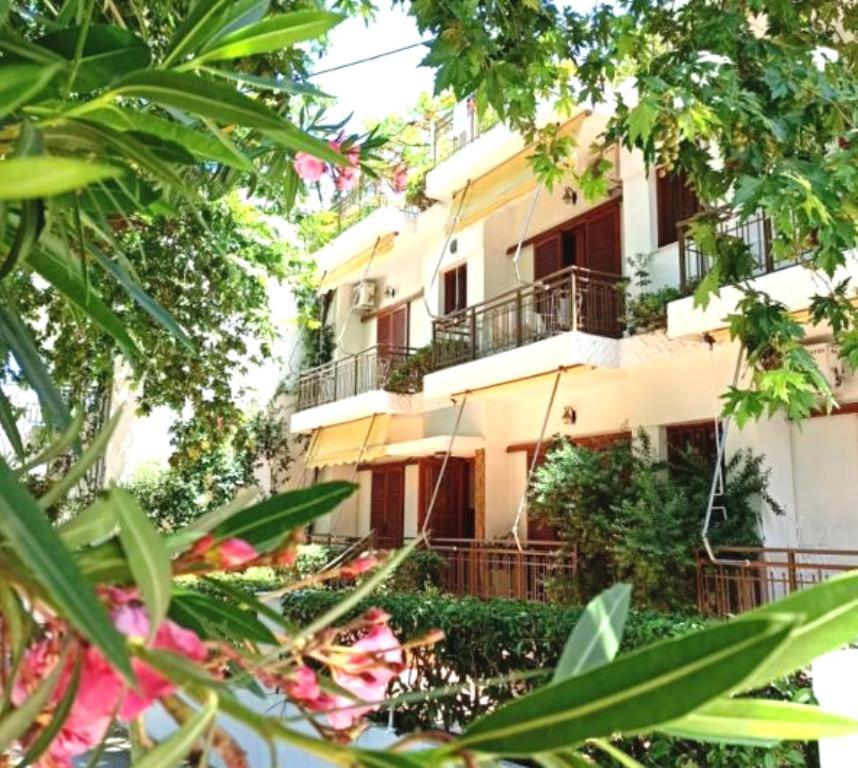 a building with a lot of trees in front of it at Apartments Papadioti in Pefki