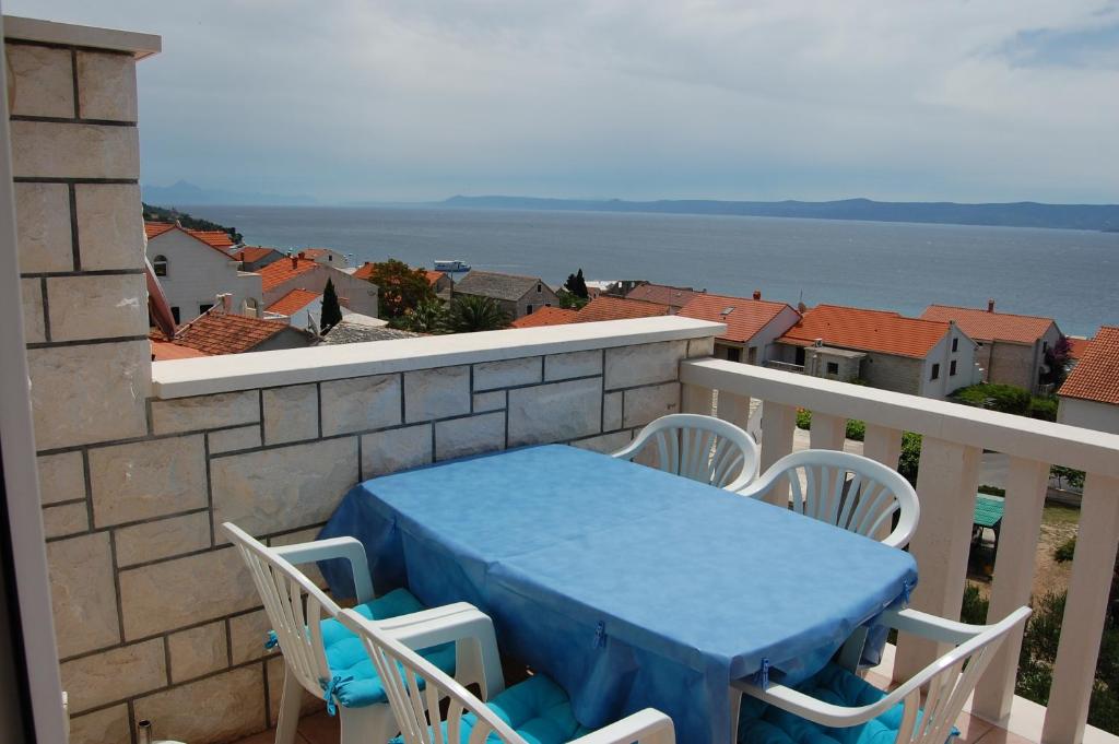 una mesa y sillas en un balcón con vistas al agua en Apartments & Rooms Pierino, en Bol