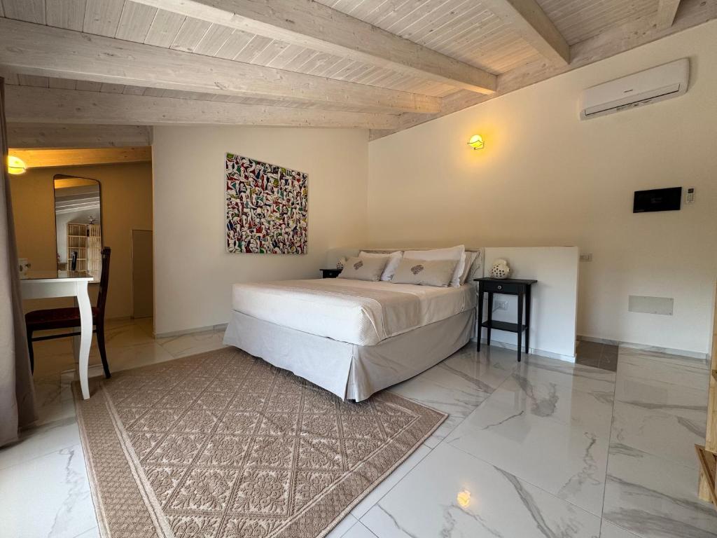 a bedroom with a bed with a painting on the wall at Tenuta Feraxi - Private Paradise in Costa Rei
