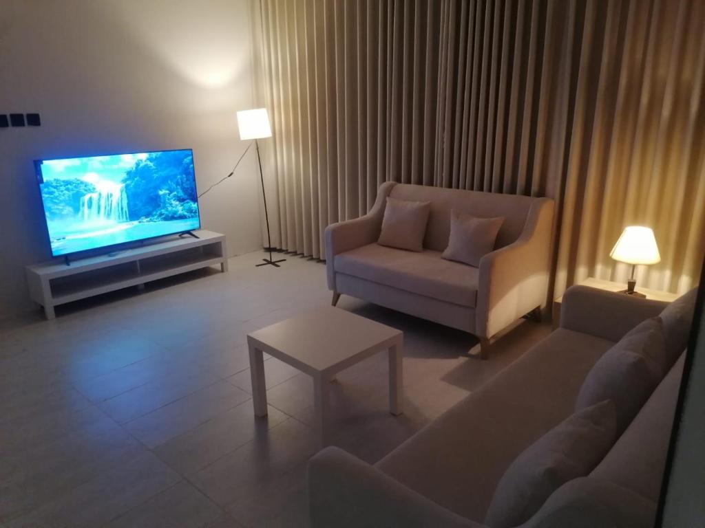 a living room with a couch and a tv at شقة 3 احد رفيدة حي الخليج in Ahad Rafidah