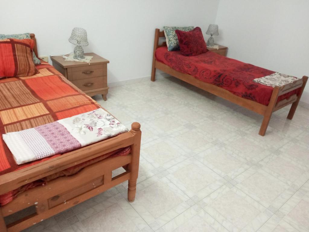 a bedroom with two beds and two night stands at Studio AMINE in Mahdia