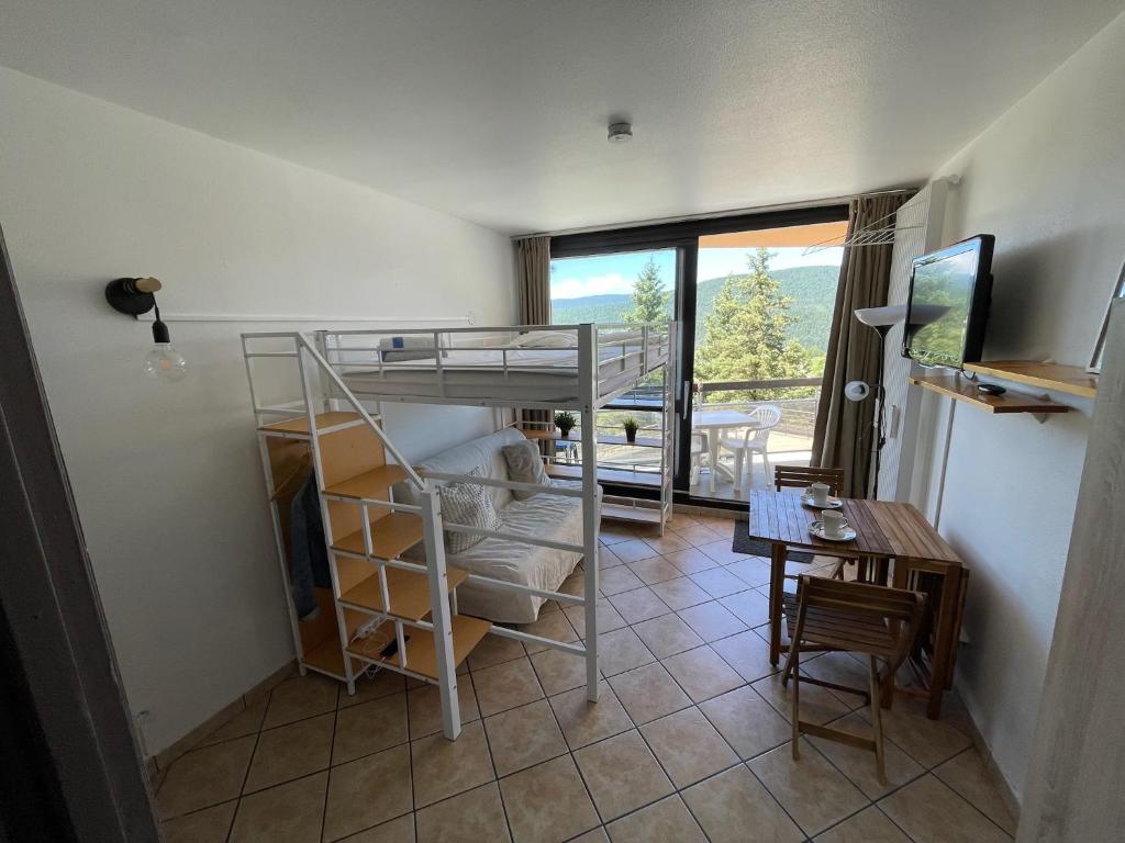 une chambre avec un lit superposé, un bureau et une table dans l'établissement studio pied des pistes coeur de station, à Villard-de-Lans