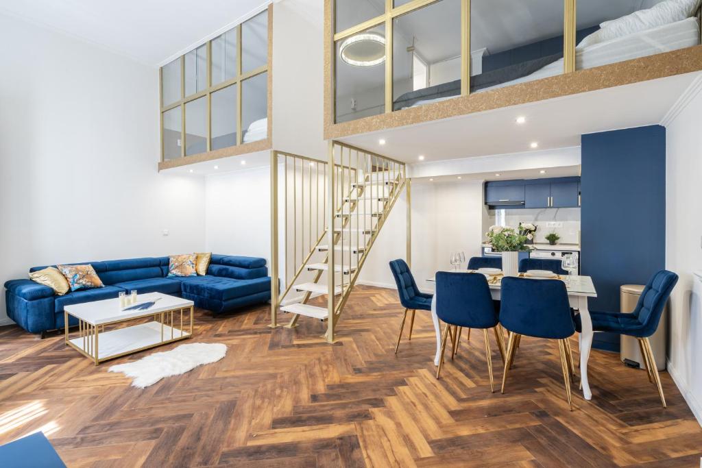 a living room with a blue couch and a table and chairs at Csarnok Apartment in Budapest