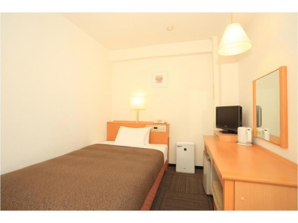 ein Hotelzimmer mit einem Bett und einem Fernseher in der Unterkunft Smile Hotel Shizuoka - Vacation STAY 76993v in Shizuoka