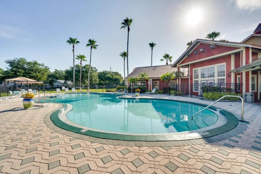 ein Swimmingpool in einem Resort mit Palmen in der Unterkunft Villa Velera Your Modern Disney Escape and other theme parks Pool, Fast WiFi & Free Parking, great for long stays in Kissimmee