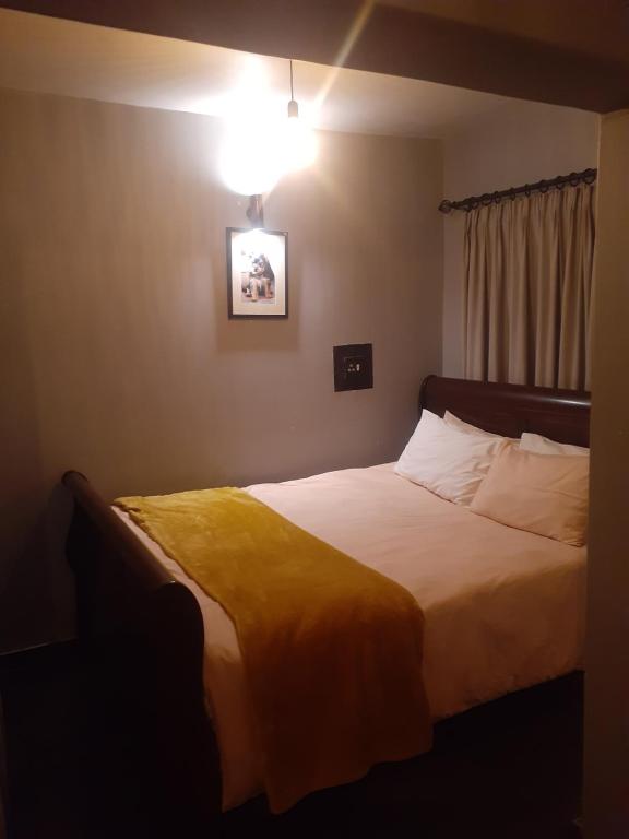1 dormitorio con 1 cama con manta amarilla en The Concept, en Centurion