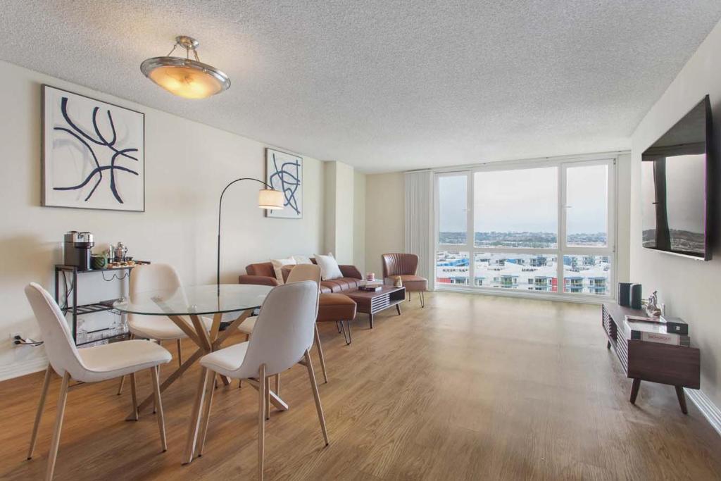 een woonkamer met een tafel, stoelen en een bank bij Marina Edge Bright 1BR 1BA Condo by the Beach in Los Angeles
