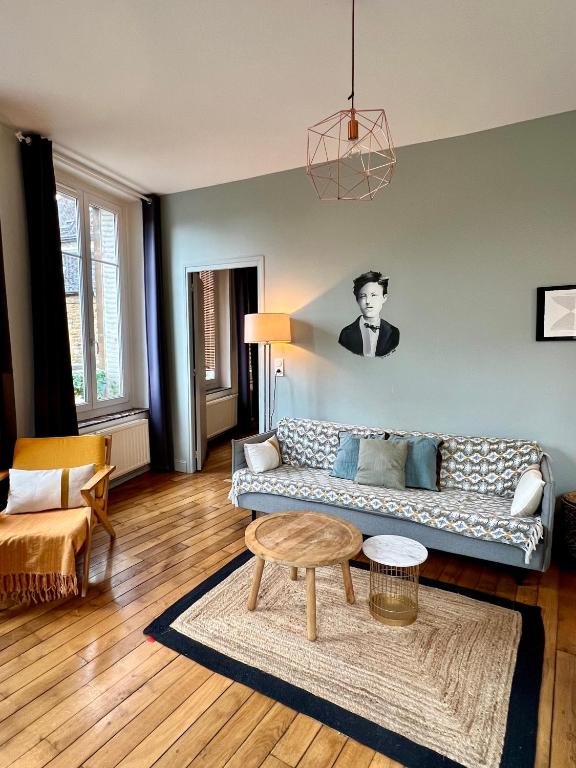 un soggiorno con un divano e un tavolo di Suite Rimbaud a Charleville-Mézières