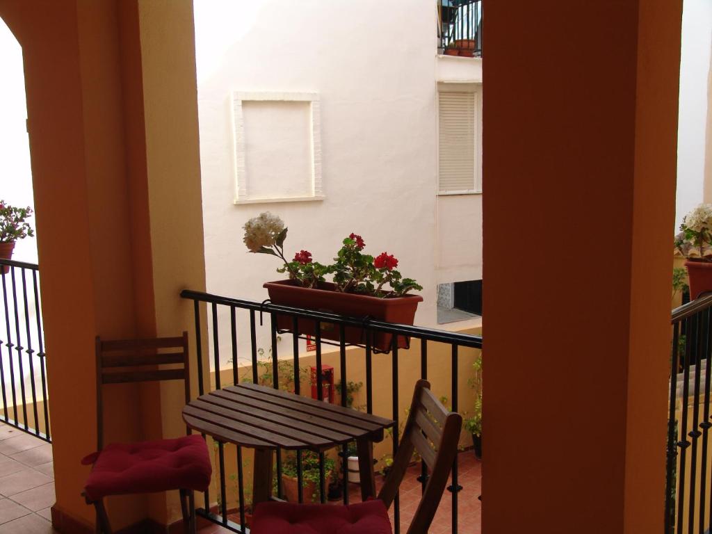 a balcony with a table and chairs and a plant at Carabeo 2000 Nerja in Nerja
