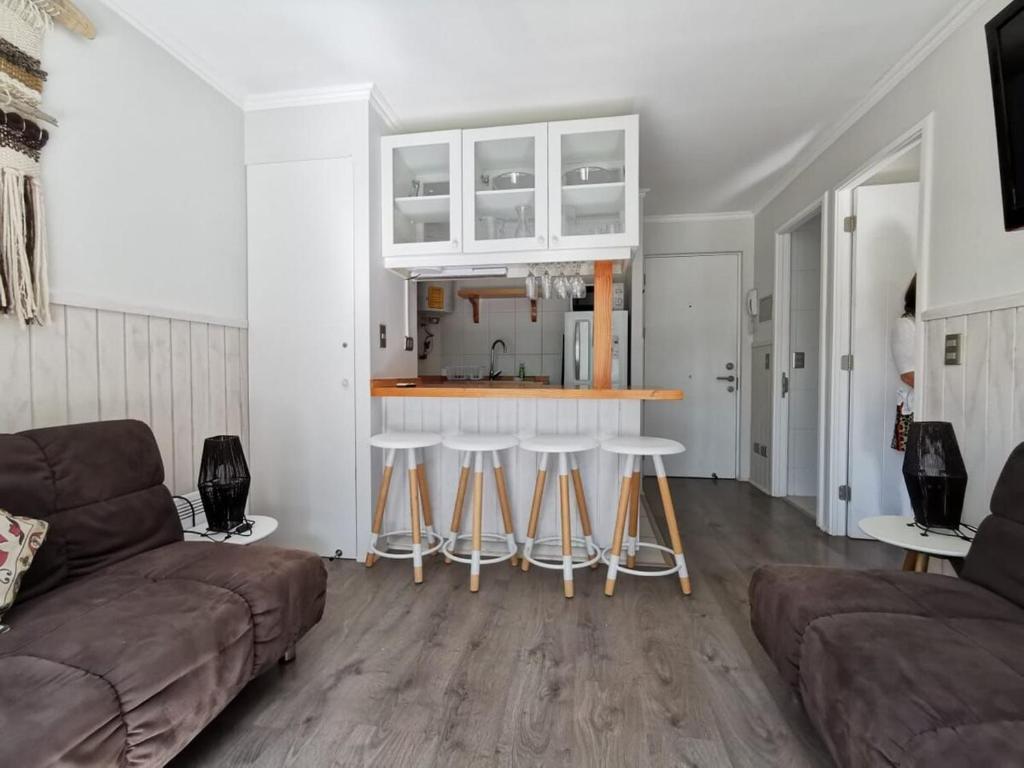 a living room with a couch and a kitchen at Cozy apartment in Pucón in Pucón