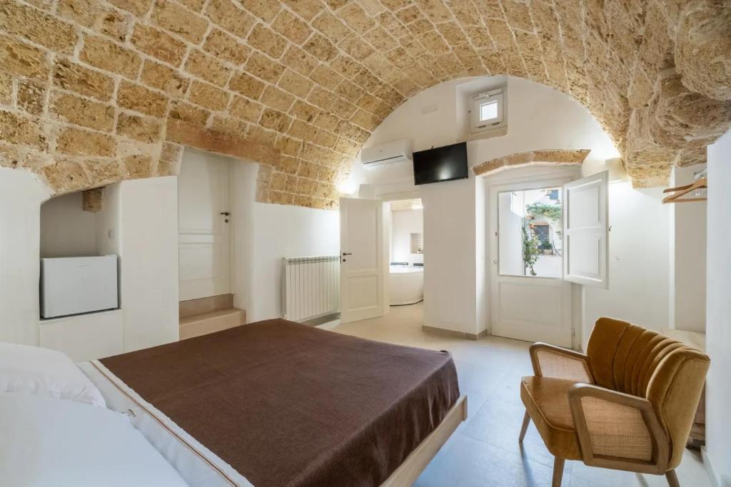 a bedroom with a bed and a stone wall at Le Antiche Dimore in Montesano Salentino
