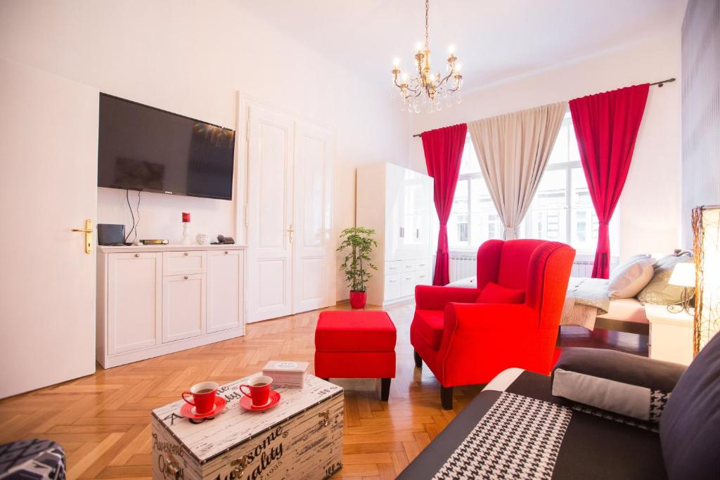 a living room with a red chair and a couch at VisitZagreb Ruby in Zagreb