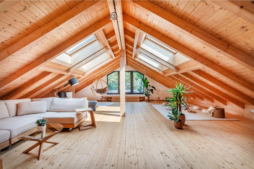 a living room with a white couch and wooden ceilings at INVITA Natur-Chalets Penthouse - Familienurlaub im Schwarzwald - 240qm in Bad Dürrheim