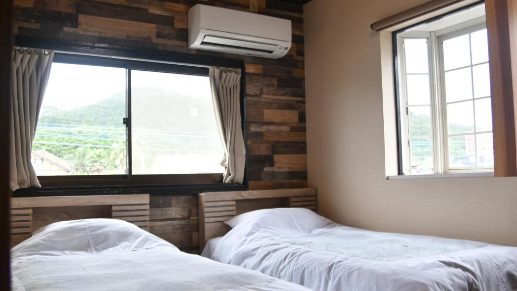 a bedroom with two beds and a window with a view at Minshuku Misakiso - Vacation STAY 89779v in Miyazaki