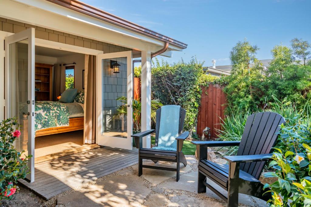 two chairs sitting on a patio next to a bedroom at Tropical Retreat North by Paradise Retreats in Santa Barbara