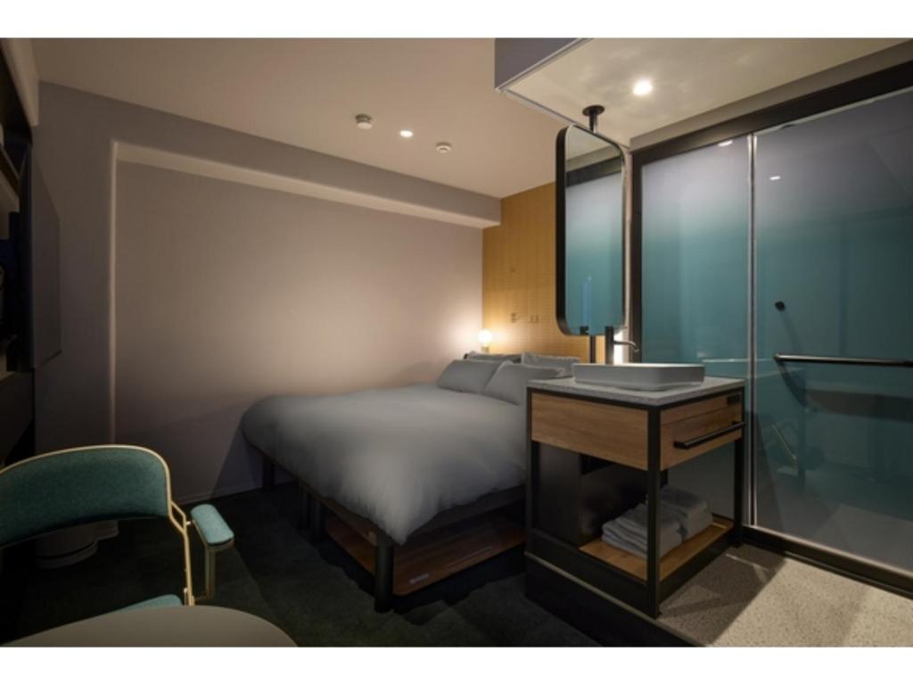 a bedroom with a bed and a desk and a mirror at BASE LAYER HOTEL NAGOYA NISHIKI - Vacation STAY 98099v in Nagoya
