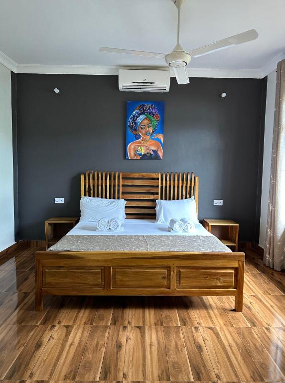 a bedroom with a large wooden bed in a room at Fukuchani Inn Hotel in Kigongoni