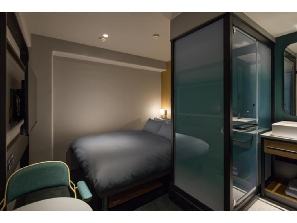 a small bedroom with a bed and a mirror at BASE LAYER HOTEL NAGOYA NISHIKI - Vacation STAY 98805v in Nagoya
