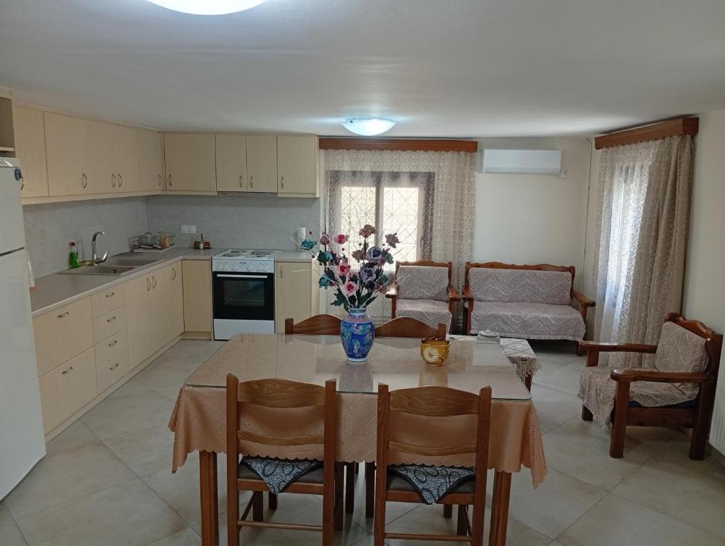 Una cocina con una mesa con un jarrón de flores encima. en Eirini's House, en Leonidio