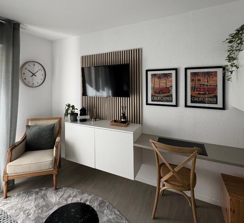 a living room with a television and two chairs at Studio Galerie 473 L'art de vivre à Metz in Metz