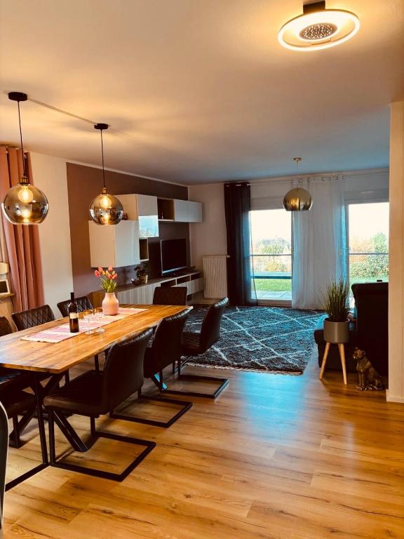 a dining room and living room with a table and chairs at Ferienhaus Dresdener Ausblick in Dresden