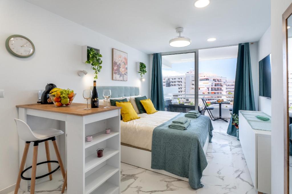 a bedroom with a bed and a desk and a window at Costa Serena Apartment 420 in Costa de Adeje
