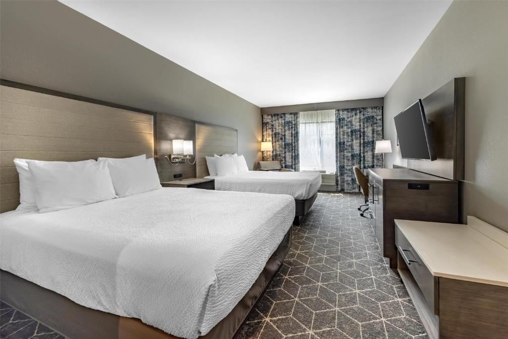 a hotel room with two beds and a flat screen tv at Best Western Plus Lawrenceburg in Lawrenceburg
