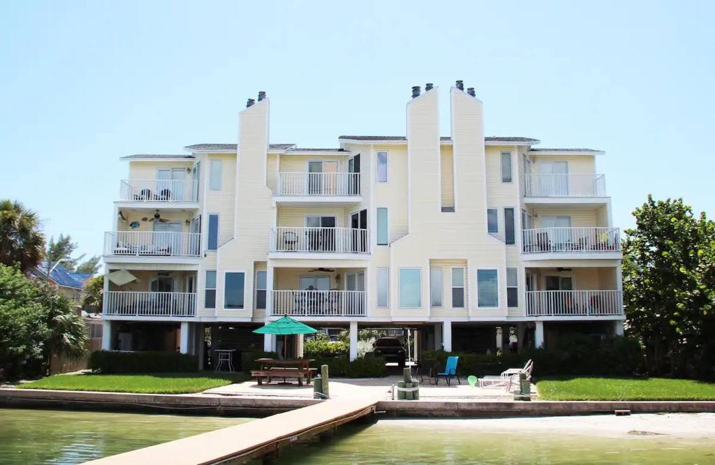 a large white building next to a body of water at Treasure Island Waterfront home - 100ft to beach! in St Pete Beach
