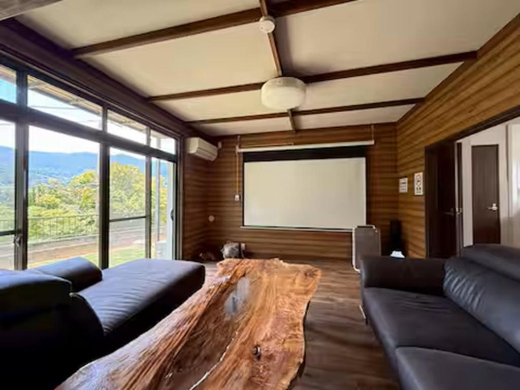 ein Wohnzimmer mit einem Sofa und einem großen Holztisch in der Unterkunft Boogie Garden - Vacation STAY 06312v in Miyakami