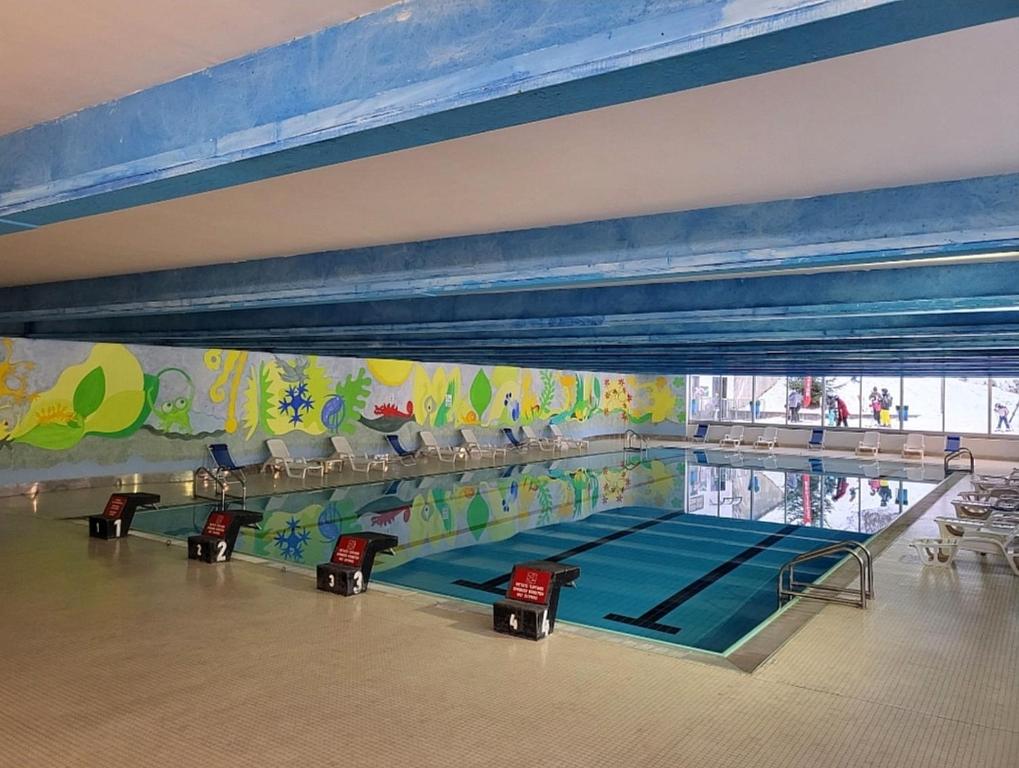 a swimming pool in a gymnasium with a swimming pool at Genziana Apartment in Marilleva