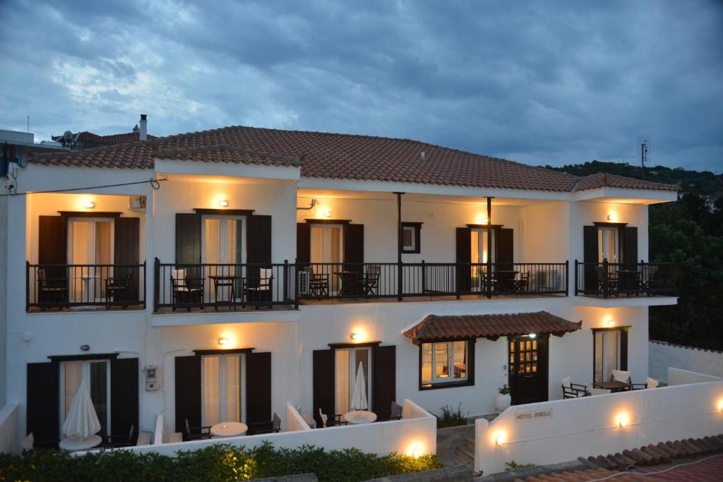 una grande casa bianca con balcone di notte di Hotel Anelli a Skopelos Town