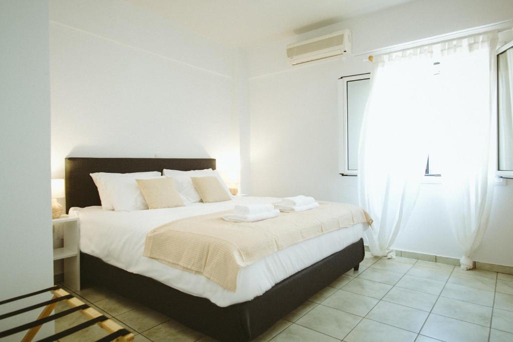 a white bedroom with a large bed with white pillows at Sea Breeze Rooms in Armenistis