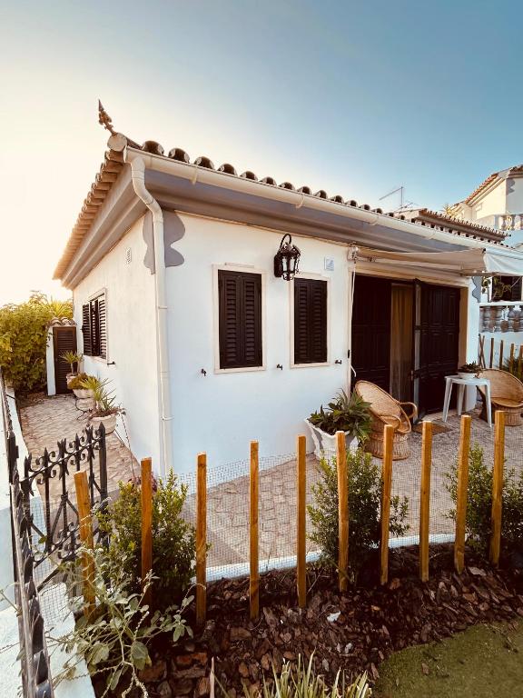 una casa bianca con una recinzione davanti di CASA DOCE - Casa Rústica no Corotelo a São Brás de Alportel