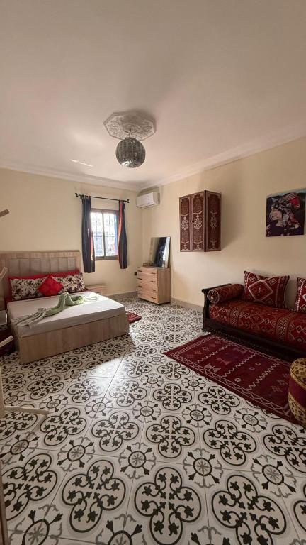 a living room with a bed and a couch at SULTAN Appartements Marrakech in Marrakesh