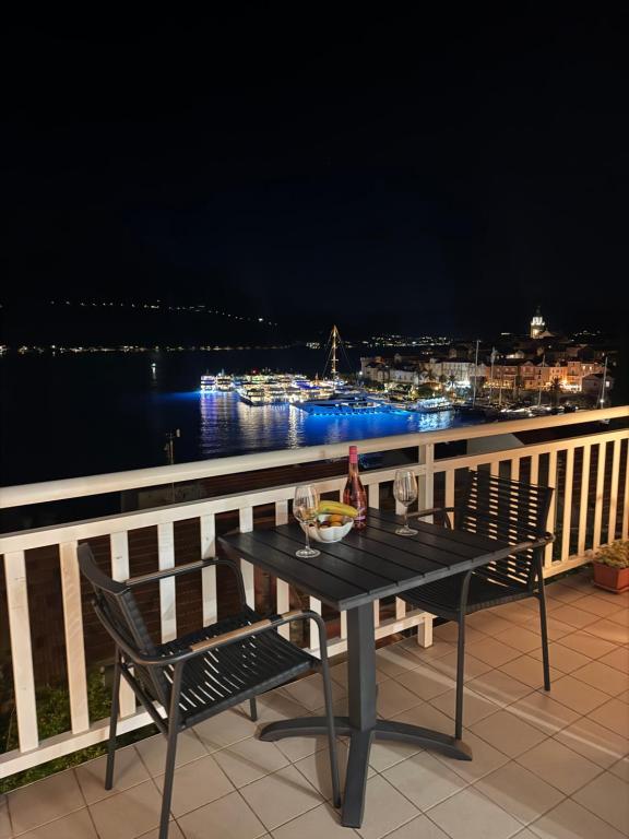 - une table et des chaises sur un balcon la nuit dans l'établissement Apartment Sea Dance, Korcula town, à Korčula