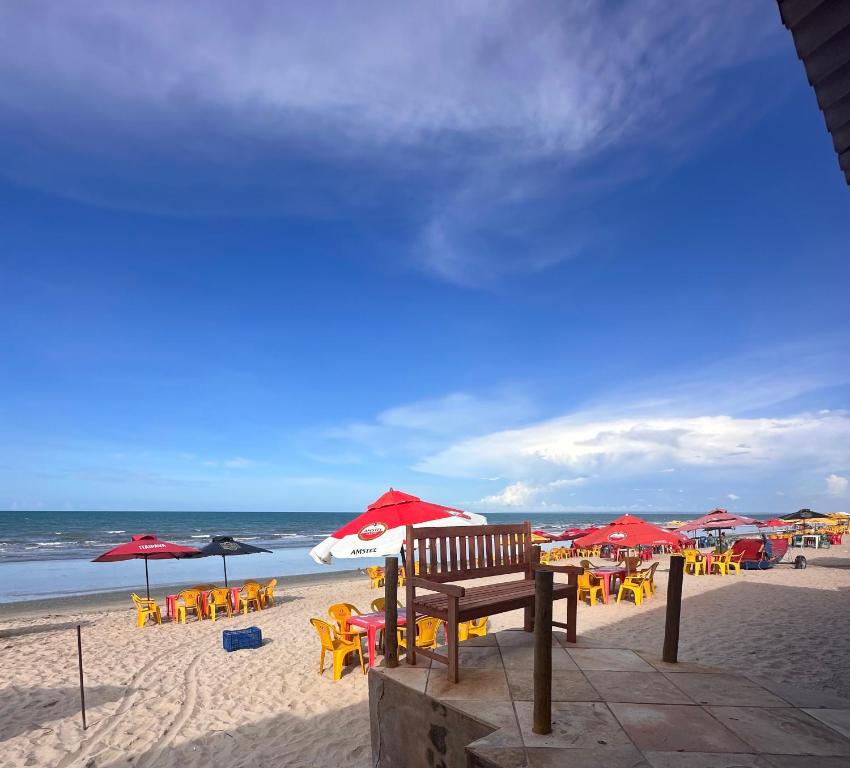 einen Strand mit Tischen, Stühlen und Sonnenschirmen in der Unterkunft Juscelino Pousada lazer in Tibau