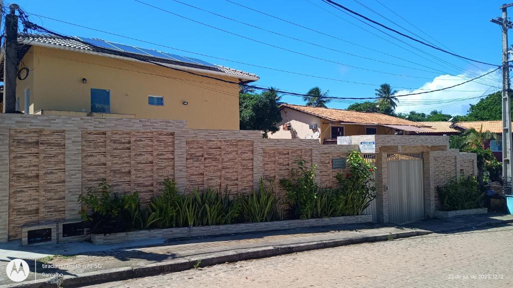 ein Ziegelzaun vor einem Haus in der Unterkunft Residencial São Francisco - Flat - Imbassai in Mata de Sao Joao