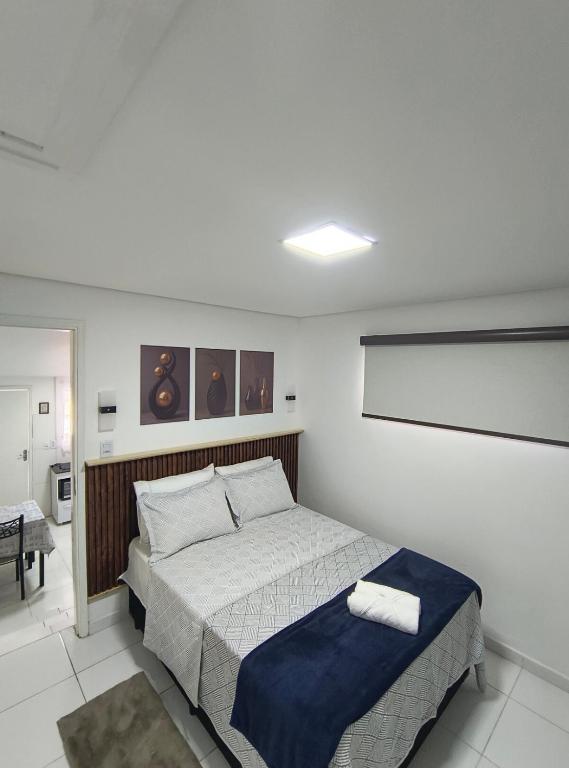 a bedroom with a bed with a blue blanket at Aconchegante Casa no centro da cidade in Itatiba