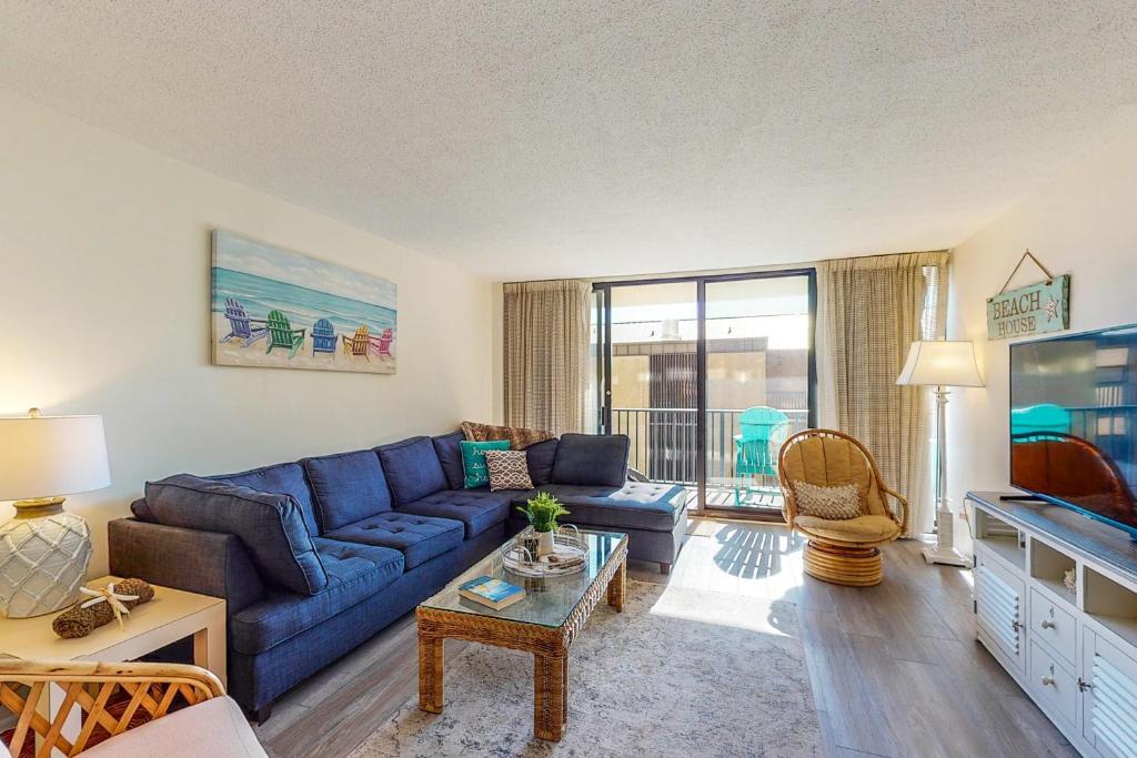 ein Wohnzimmer mit einem blauen Sofa und einem Fernseher in der Unterkunft Sea Colony - 204 Brandywine House Rd in Bethany Beach