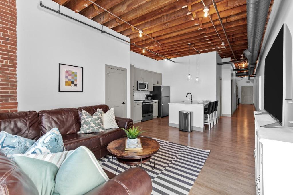 una sala de estar con un sofá y una mesa en Stay in Style! Stunning River View - King Bed, en Saint Louis