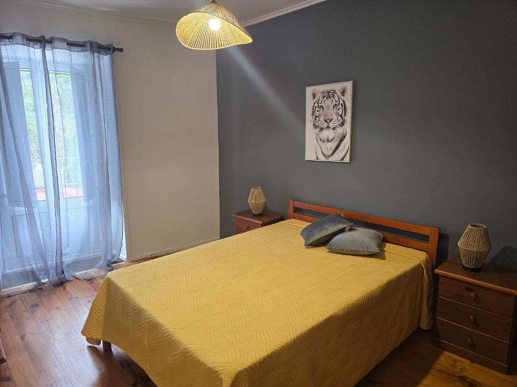 a bedroom with a bed with a yellow bedspread at Casa Apito Dourado in Ponta Delgada