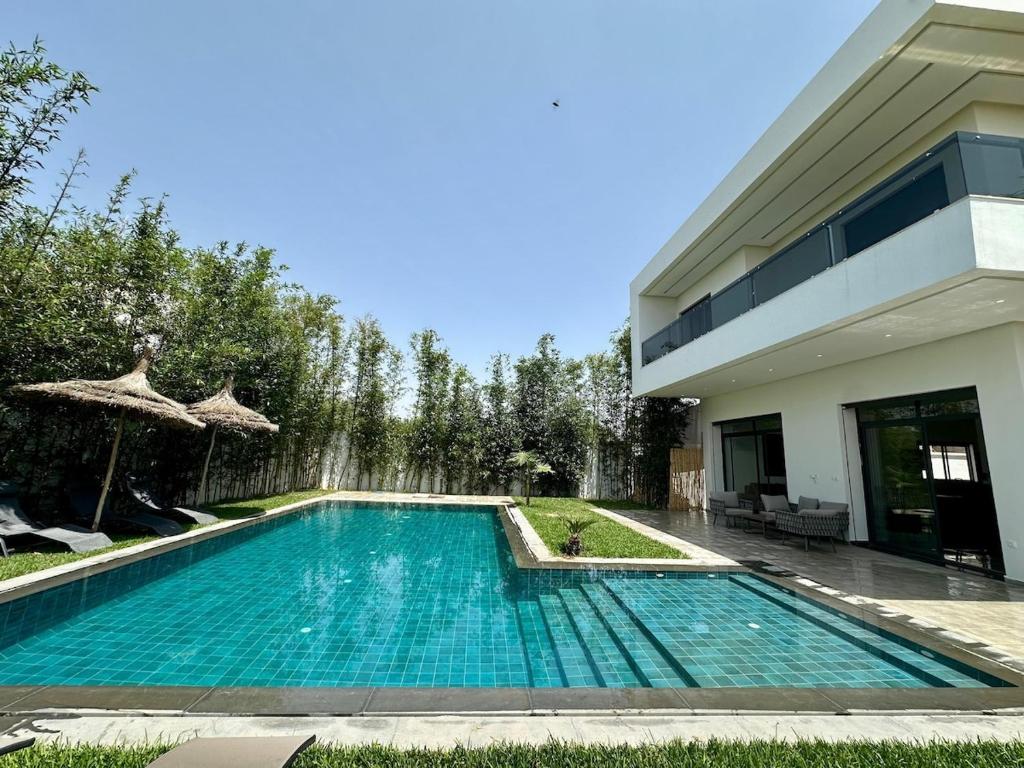 a swimming pool in front of a house at Villa 6chambres Aéroport de Fès Piscine Jacuzzi in Fès