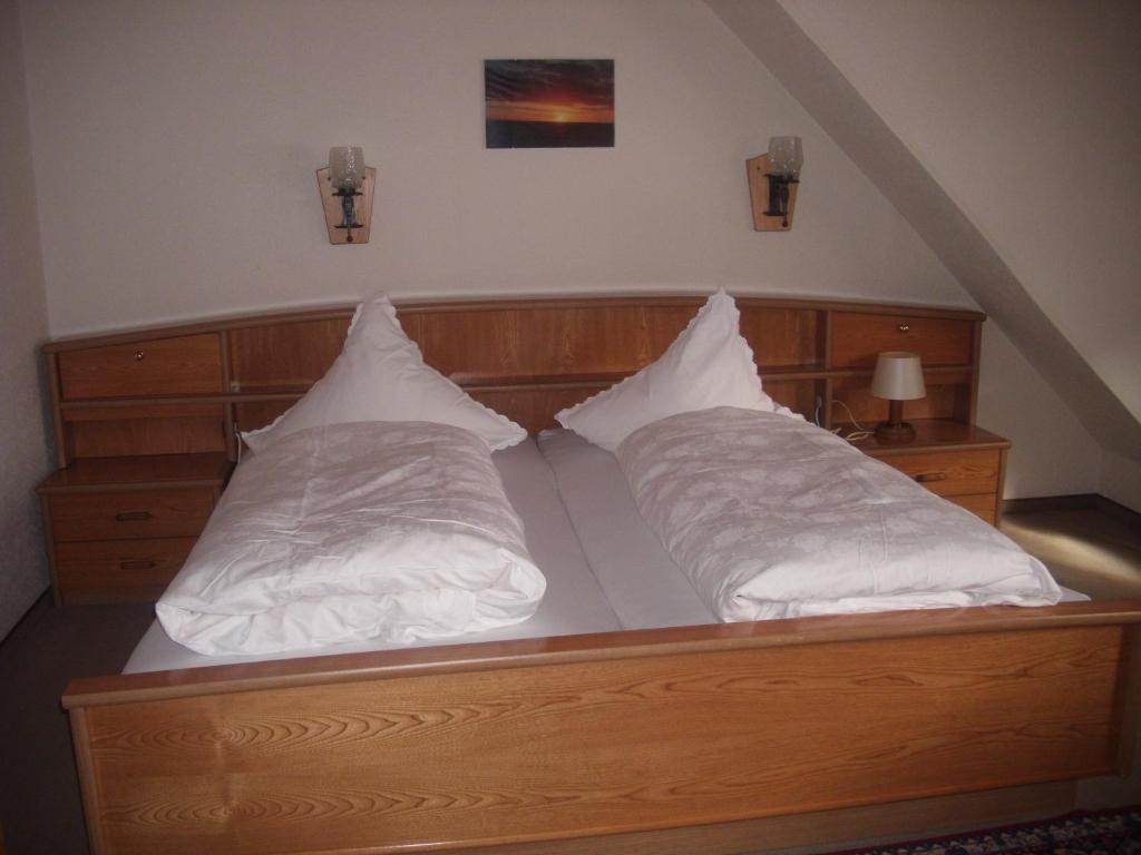 a bed with white sheets and pillows on it at Landhotel Pingel in Sundern