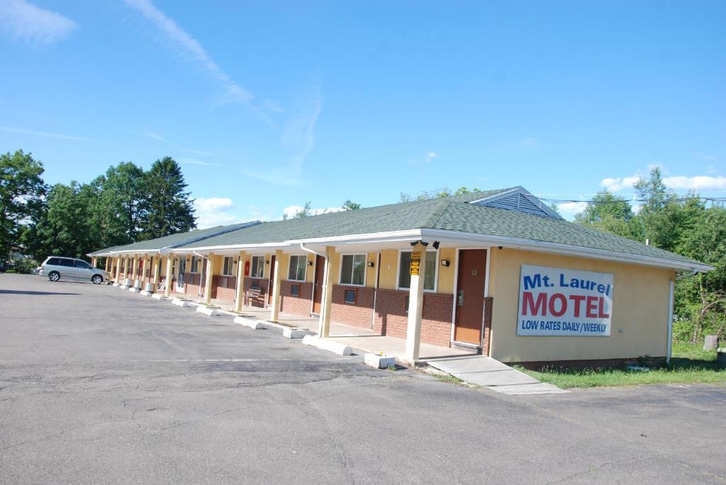un edificio con un cartel de motel en un estacionamiento en Mount Laurel Motel, en Hazleton