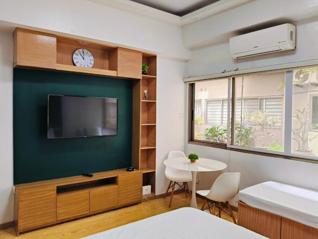 バギオにあるCEDAR PEAK by AWESOME STAY in Baguioのテレビとテーブルのあるリビングルーム