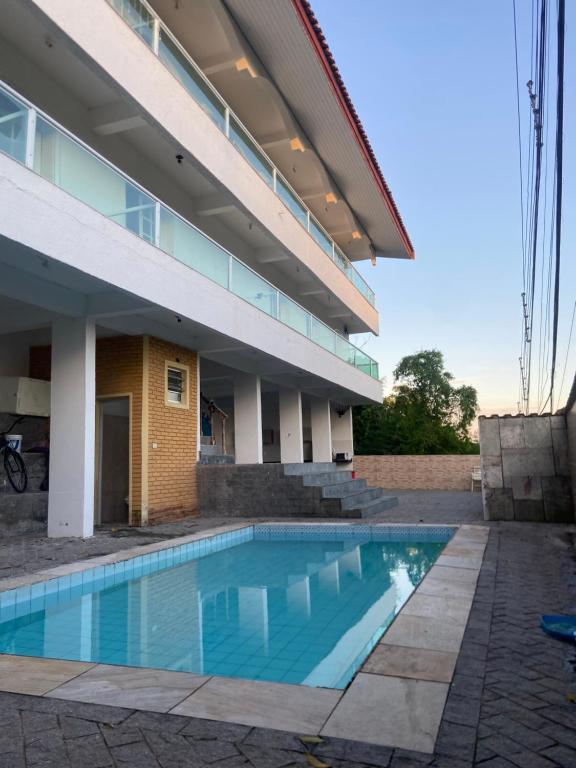 a swimming pool in front of a building at Suites mirante da Enseada in Guarujá