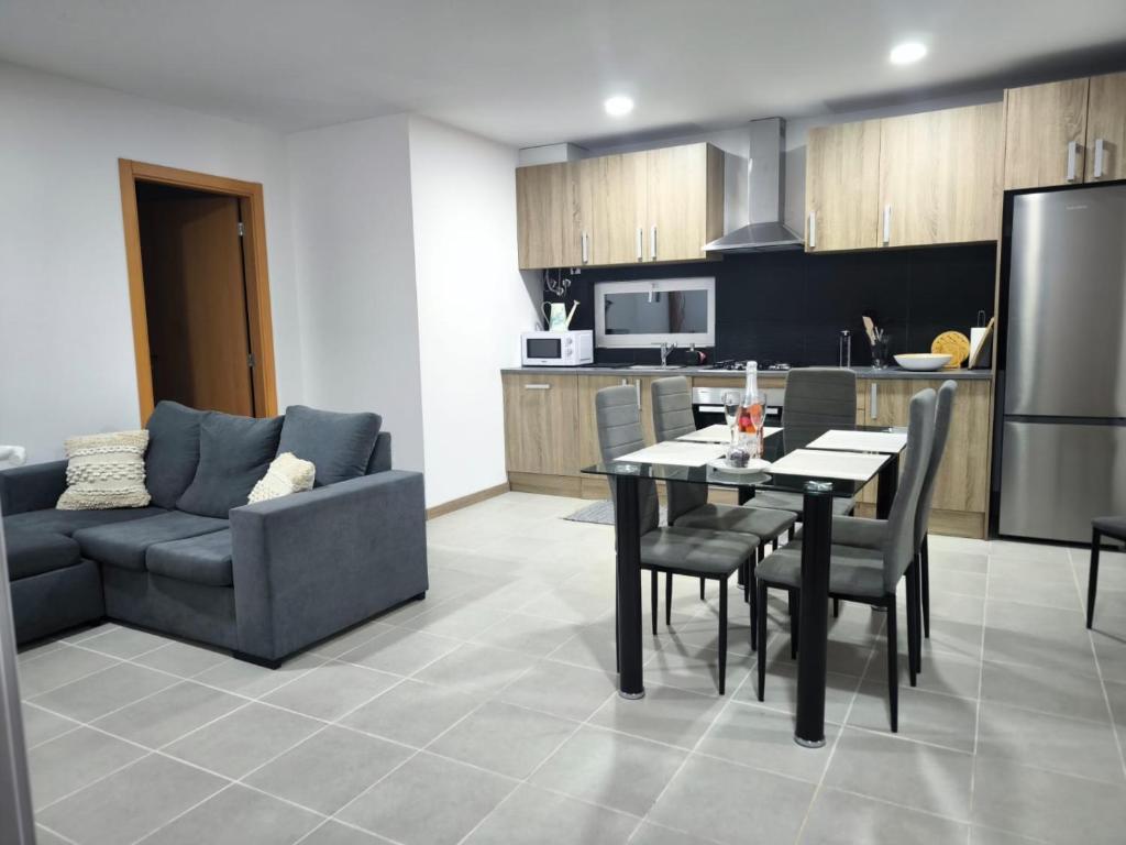 a kitchen and living room with a table and a couch at Casa do campo in São João