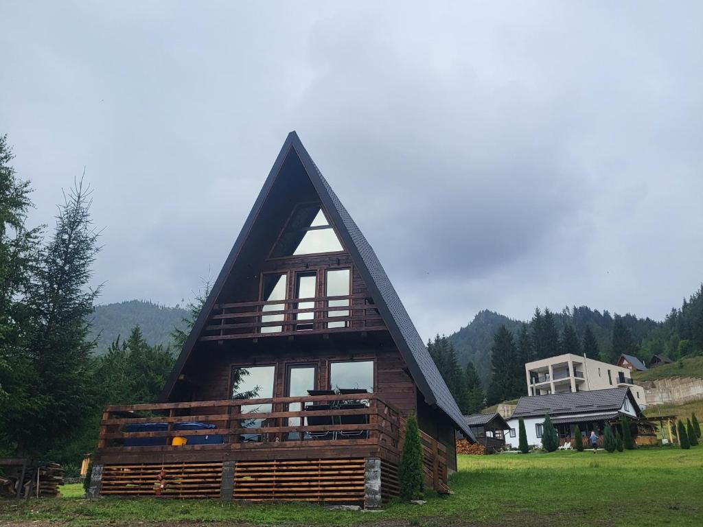 een groot houten huis met een schilddak bij Rivera Cabin in Colibiţa
